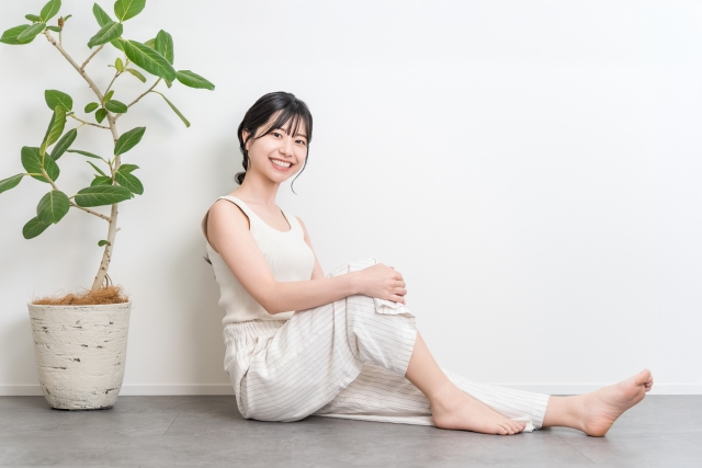 フローリングに座る笑顔の美しい女性