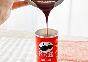 チップスの入った筒に溶かしたチョコを流し込む様子