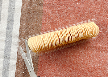 プラスチックトレーの端をハサミで切り取る工程
