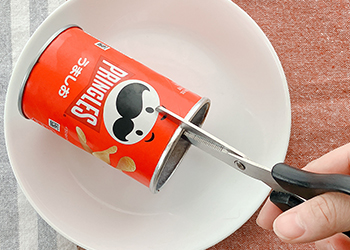 固まった後、プリングルズの筒にハサミで切れ目を入れる様子